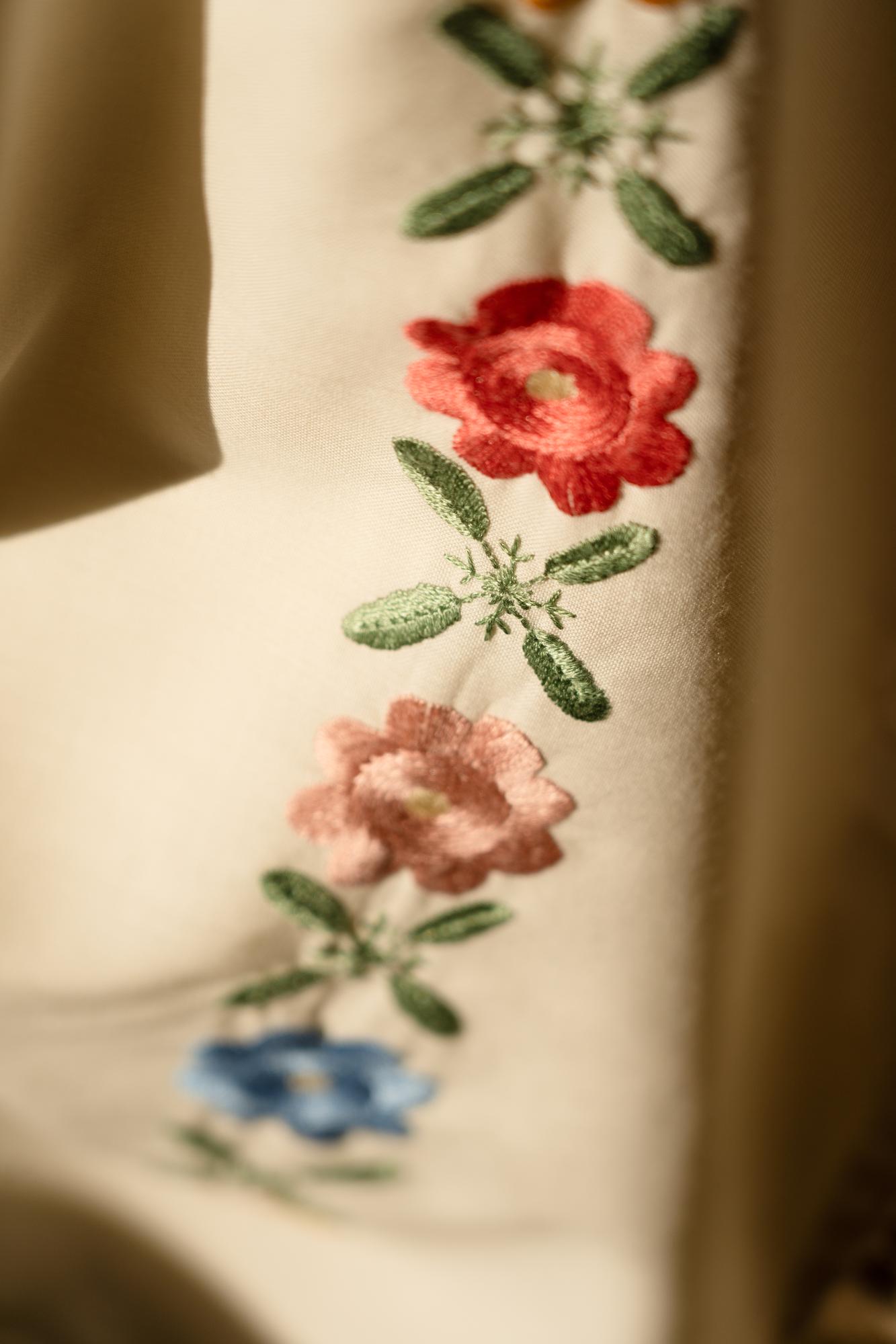 close-up of hand embroidery on linen with floral motifs
